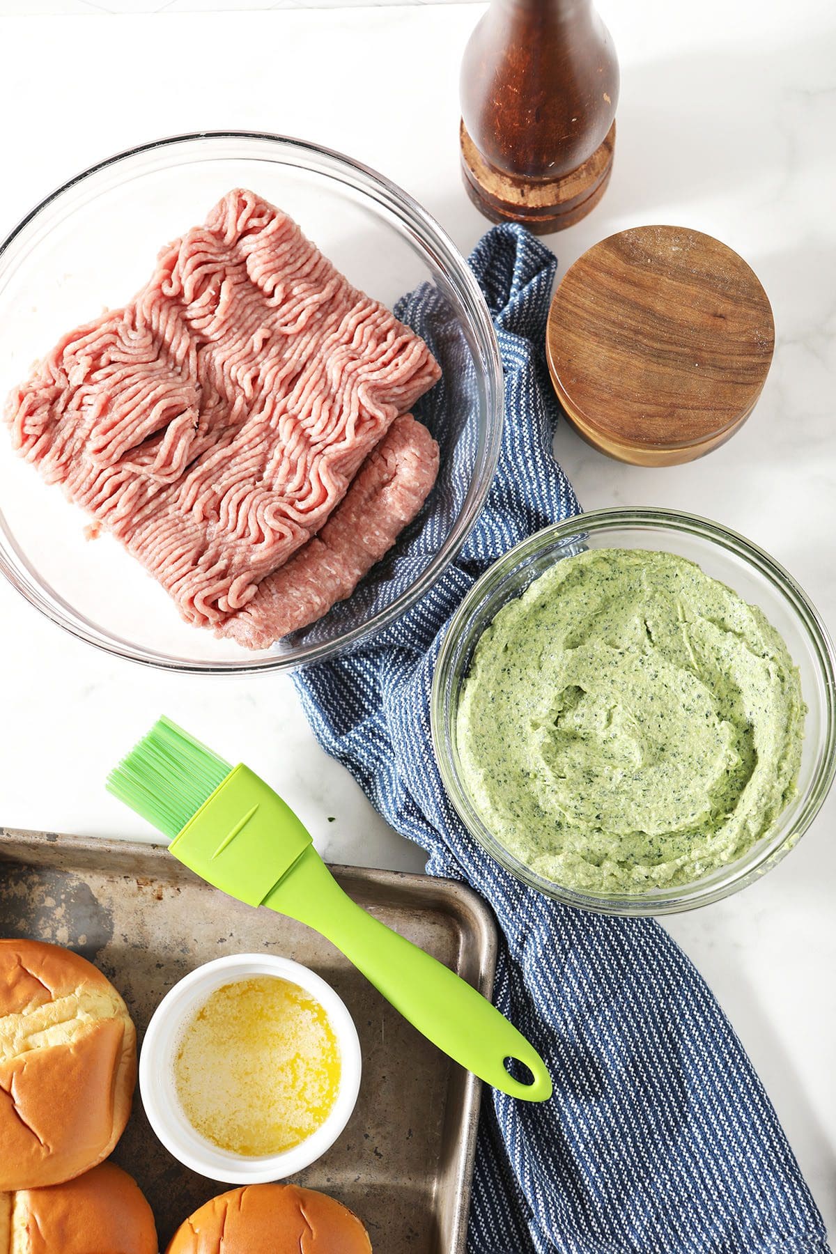 Ingredients to make stuffed turkey burgers in bowls on marble