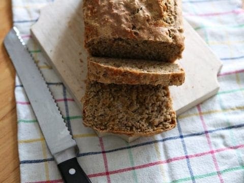 Sliced bread on cutting board next to knife 