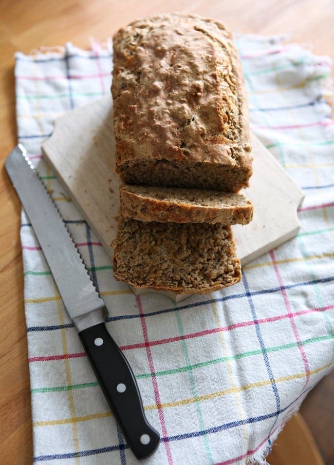 Sliced bread on cutting board next to knife 