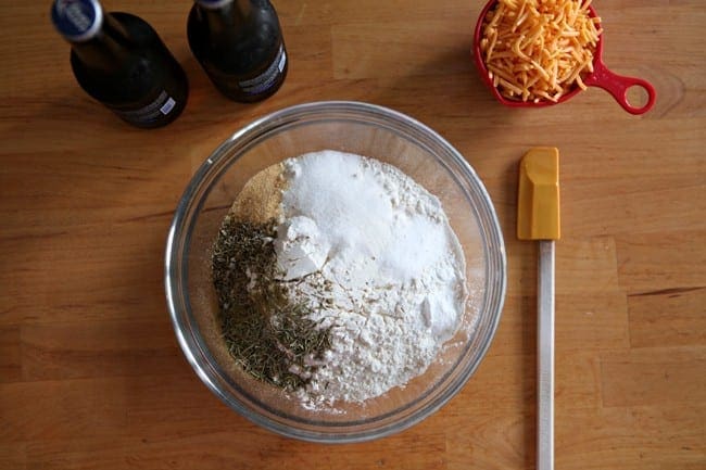 Overhead view of glass bowl filled with ingredients next to spatula 