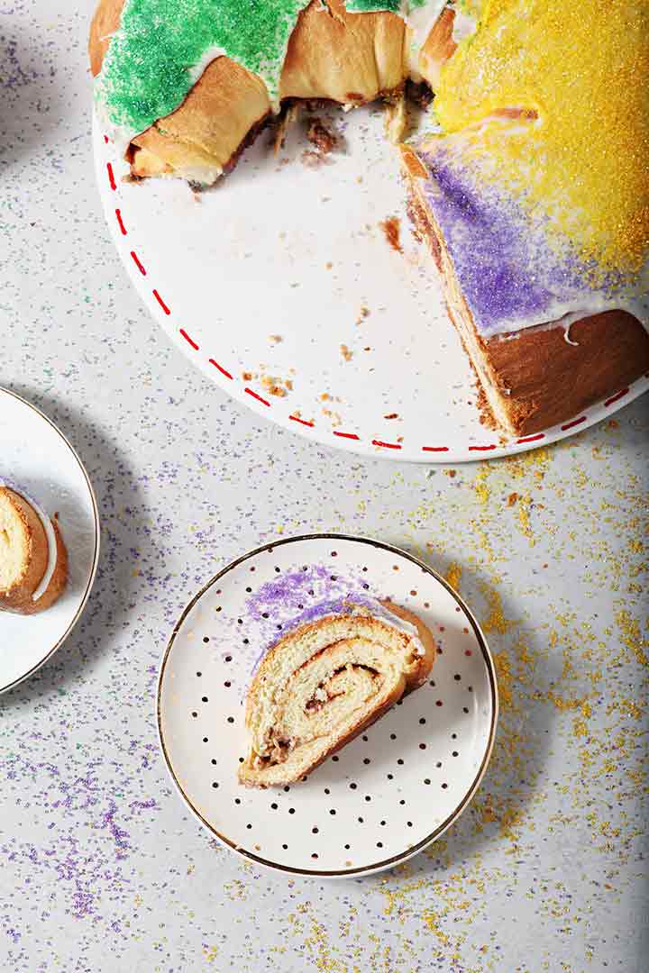 Slices of a stuffed King Cake on a gray surface