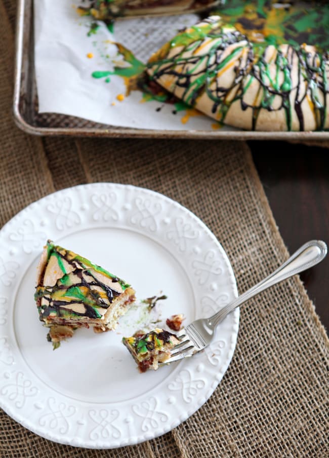 raspberry and cream cheese king cake on a white plate with a fork