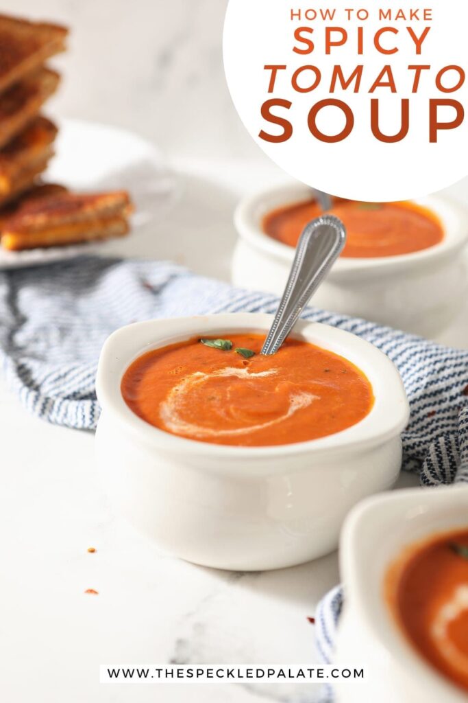 Three pottery bowls of tomato soup with spoons in them on a blue striped towel with the text 'how to make spicy tomato soup'