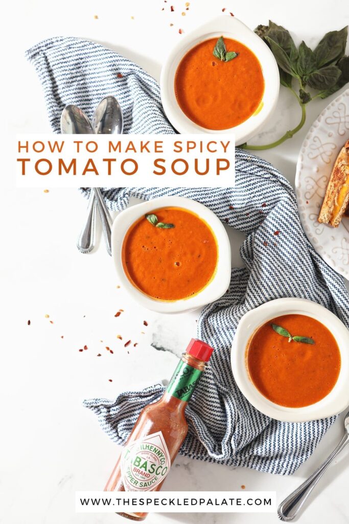 Three bowls of tomato soup sit on a blue striped towel next to a plate of grilled cheese wedges and a bottle of Tabasco with the text 'how to make spicy tomato soup'