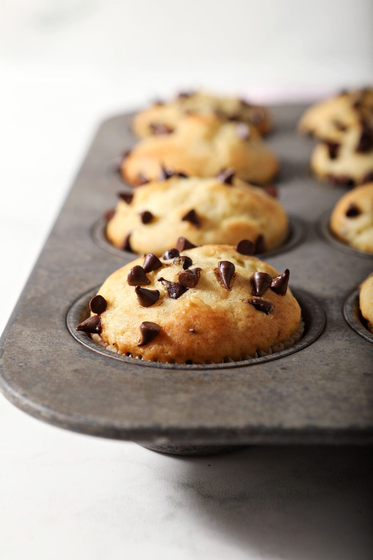 Chocolate Chip Muffins in a muffin tin on marble