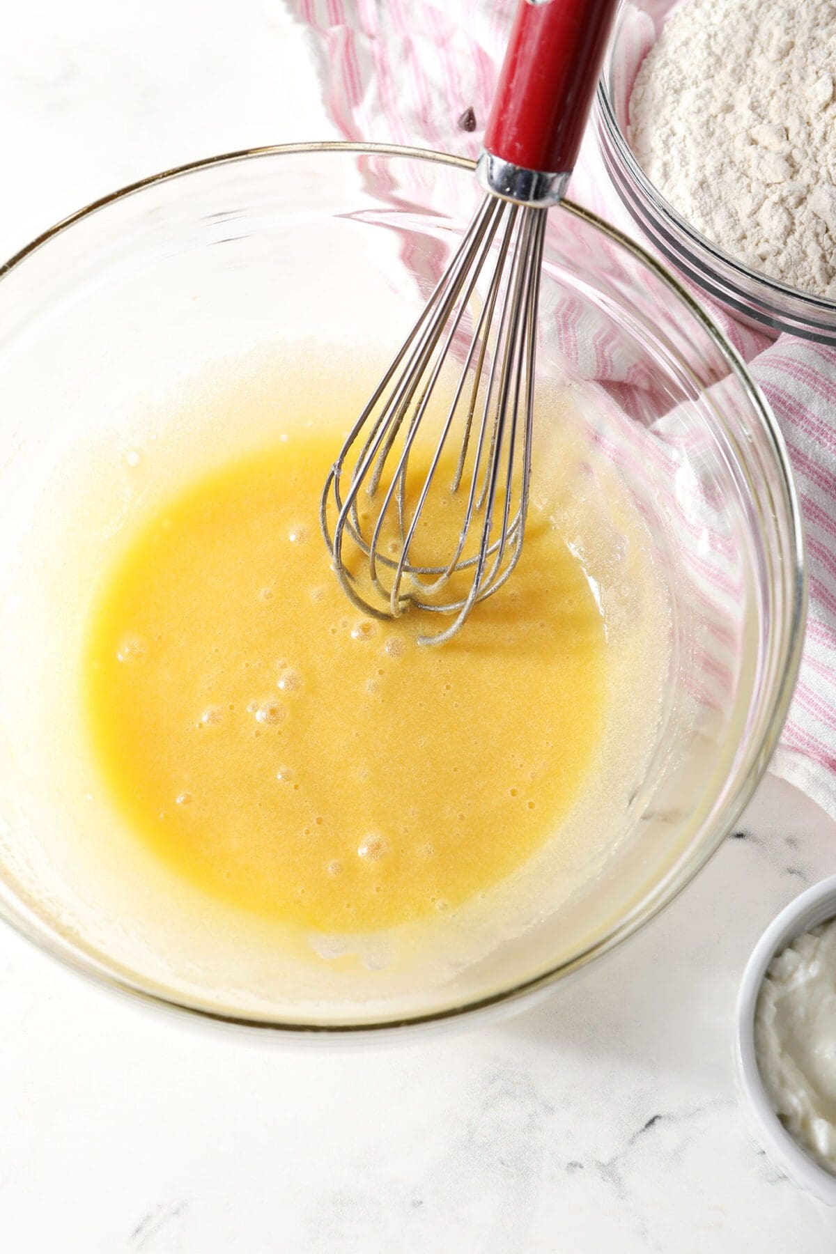 Wet ingredients for muffins in a bowl with a whisk