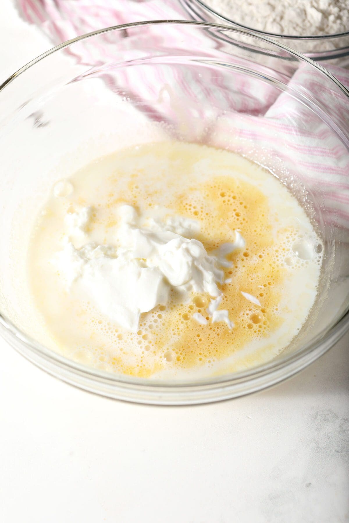 Milk and Greek yogurt on top of other wet ingredients for muffins