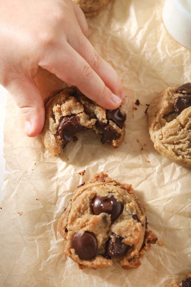 A girl grabs a half-bitten into Dark Chocolate Chip Cookie