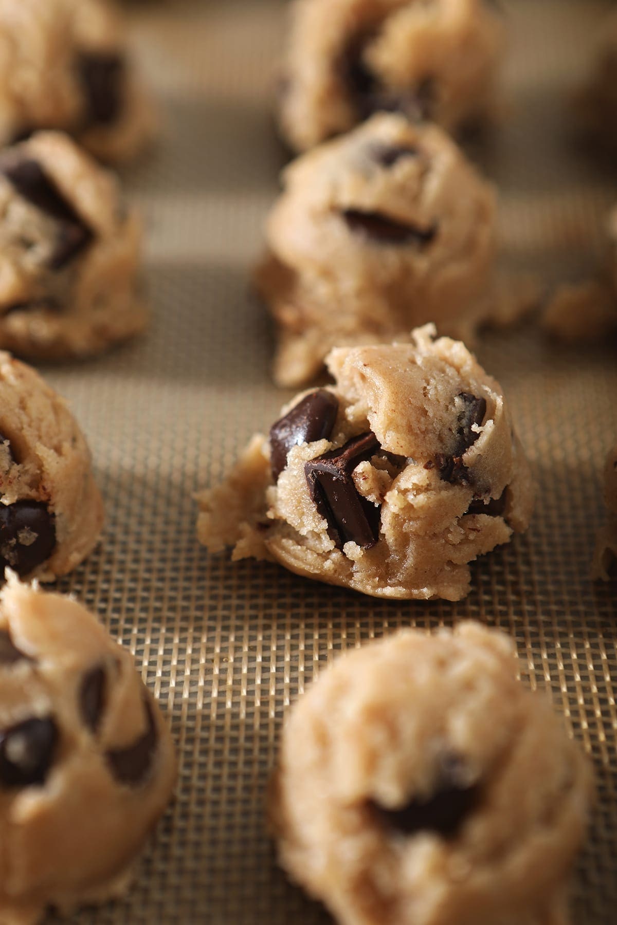 Chocolate Chip Cookie Dough, in scoops, is shown on a baking sheet before it chills