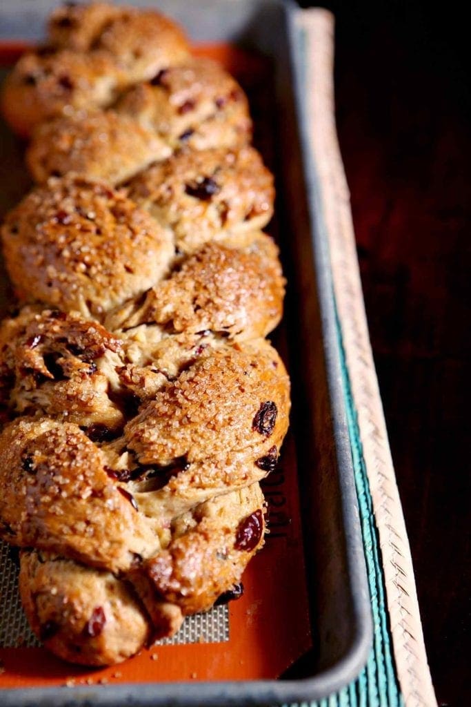 A close up of baked fruit studded holiday bread in a pan 