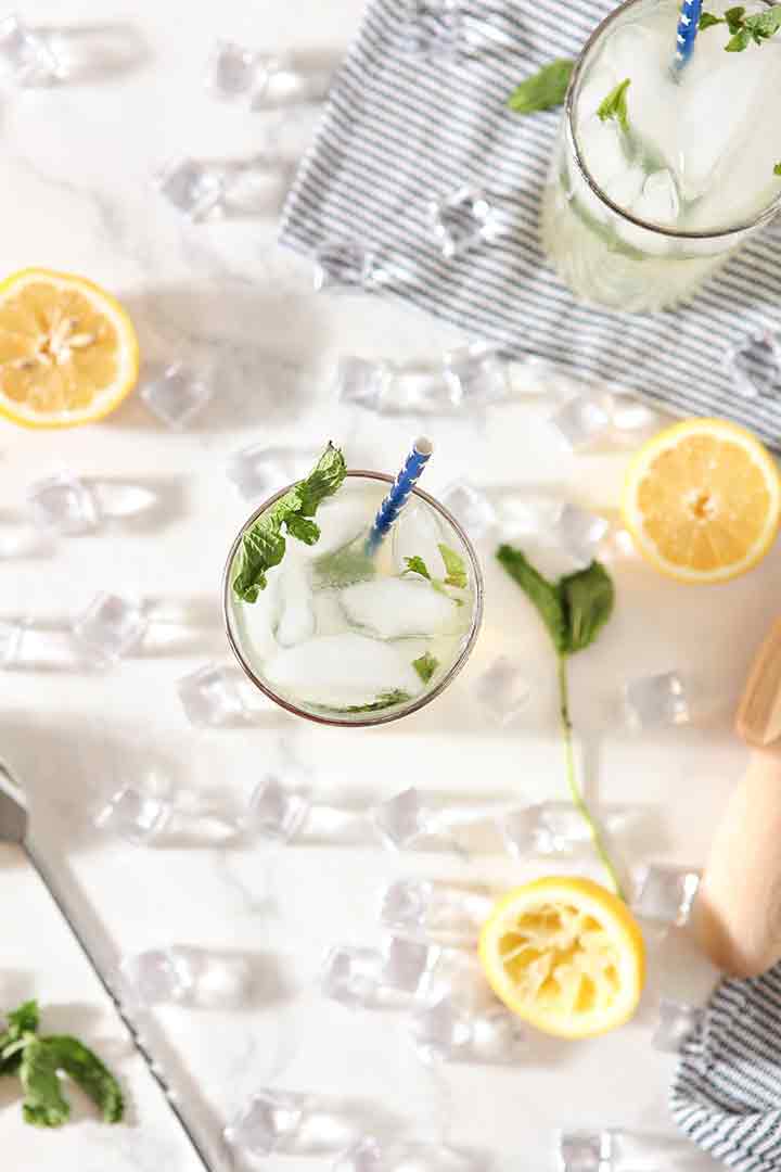 Overhead of a glass of Mint Lemonade, surrounded by ingredients