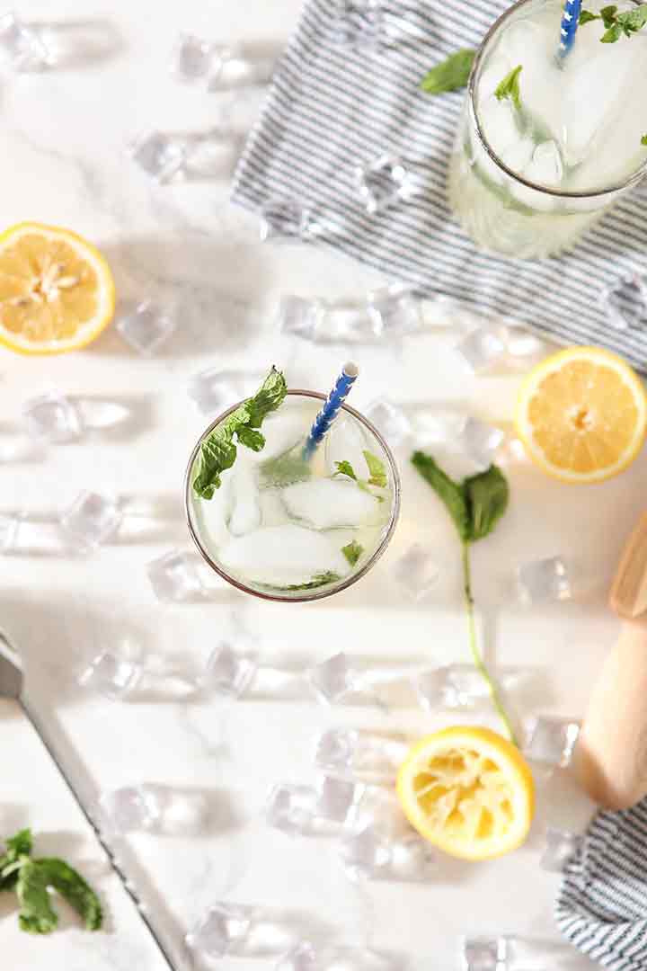 Overhead of a glass of Mint Lemonade, surrounded by ingredients