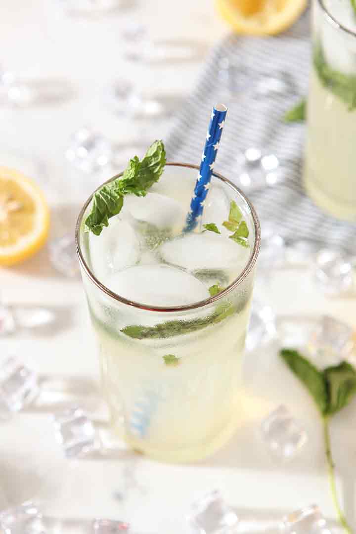 Close up of Mint Lemonade in a glass, surrounded by ice