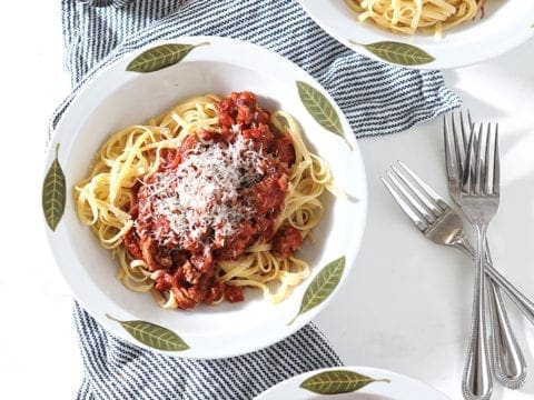Overhead of three bowls of Turkey Pasta Sauce, topped with cheese