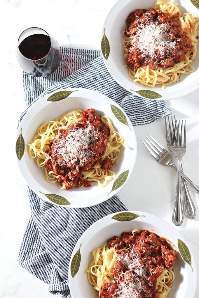 Overhead of three bowls of Turkey Pasta Sauce, topped with cheese