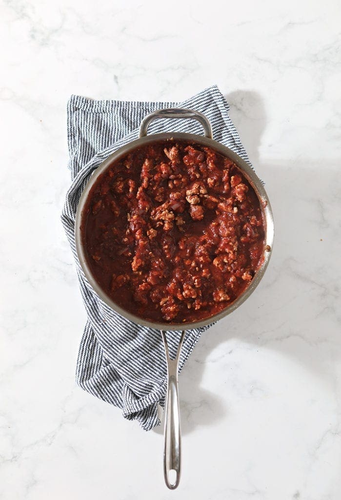 A saucepan holds meaty pasta sauce, shown from above