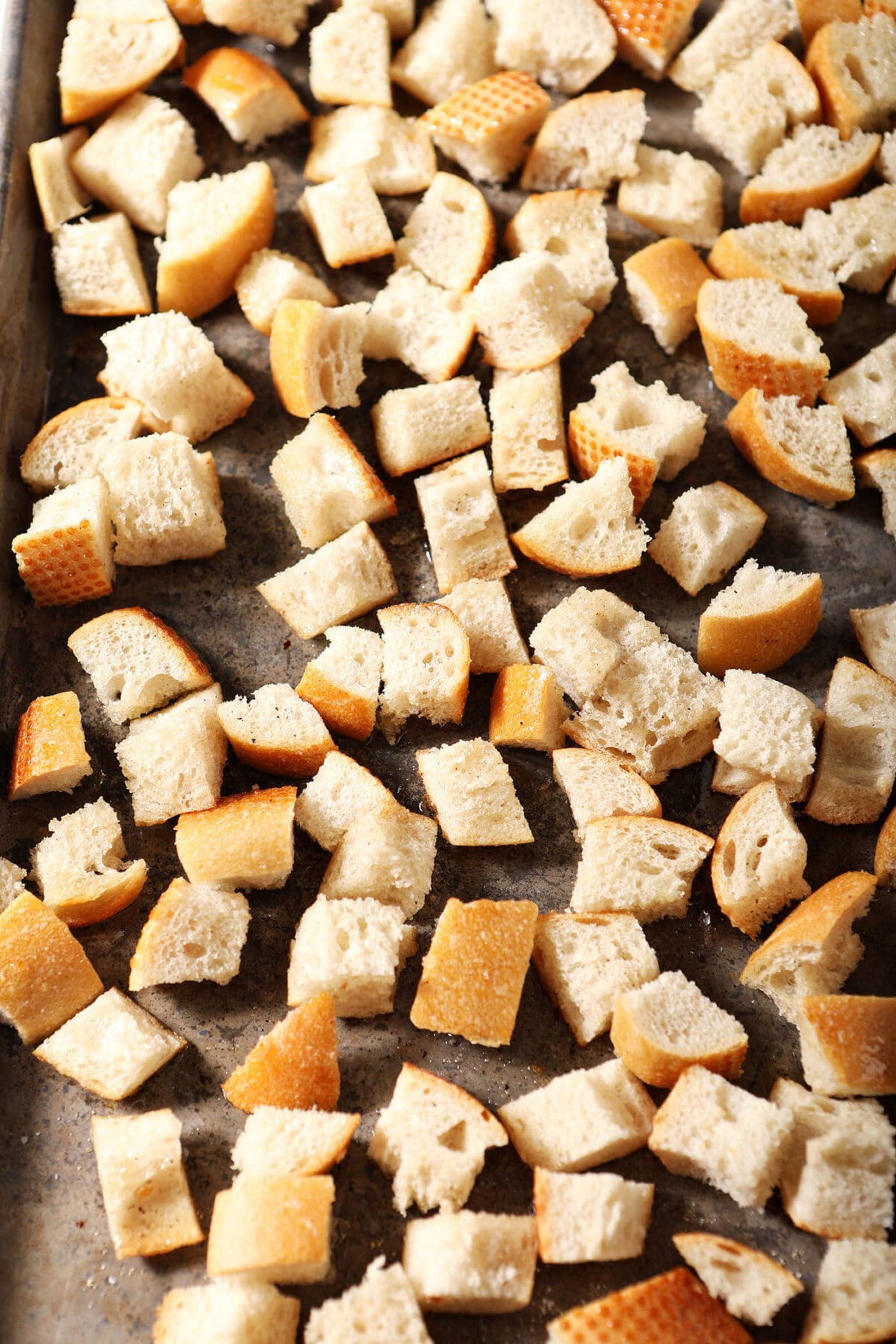 cubed bread on a sheet pan before baking