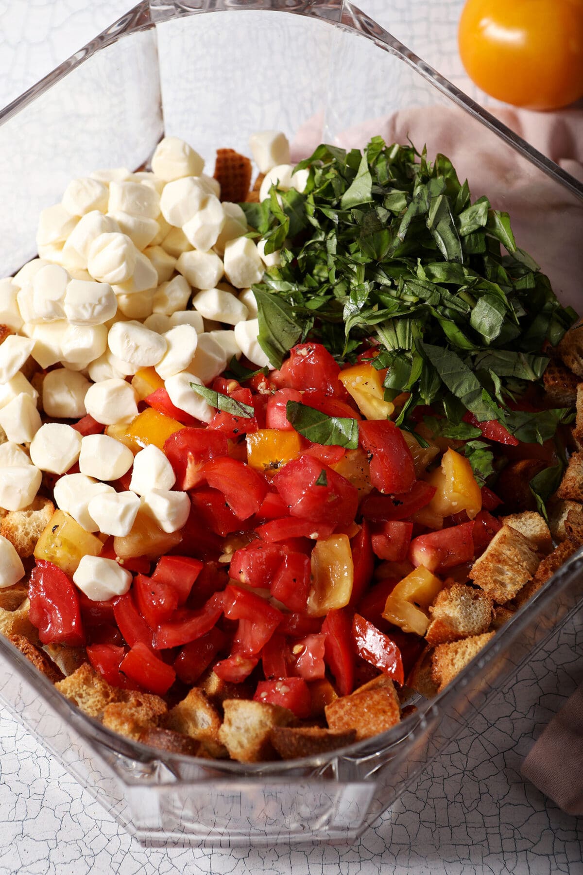 all the ingredients to make panzanella salad in a large bowl before mixing