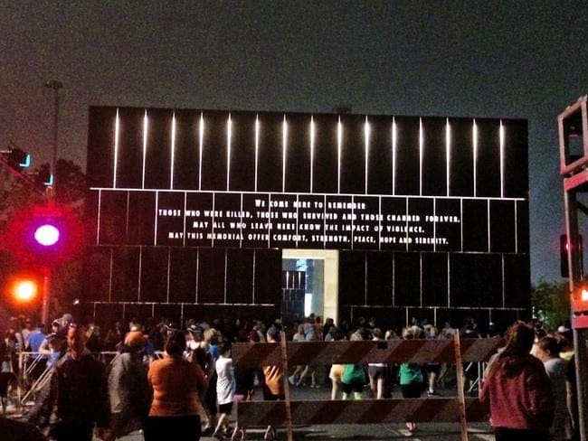 A crowd of people looking at a large screen 