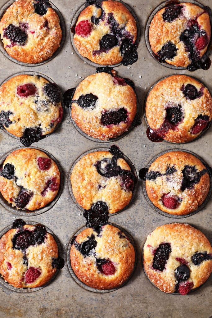 A muffin pan full of mixed berry muffins after baking