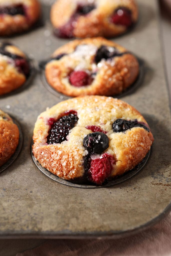 Baked mixed berry muffins in a tin after baking