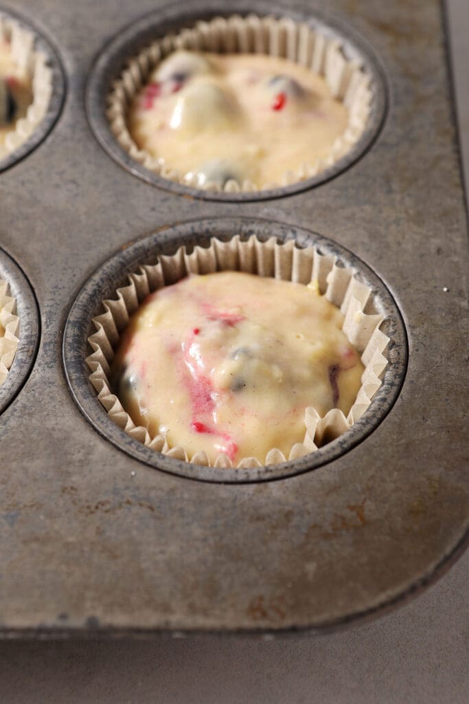 Berry muffin batter in muffin cups before baking