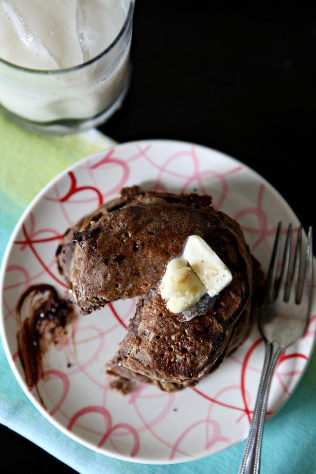 Overhead view of slice cut out of stack of pancakes on plate