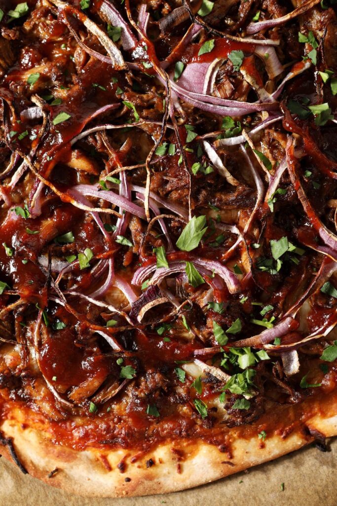 Close up of final bbq pulled pork pizza garnished with parsley or cilantro