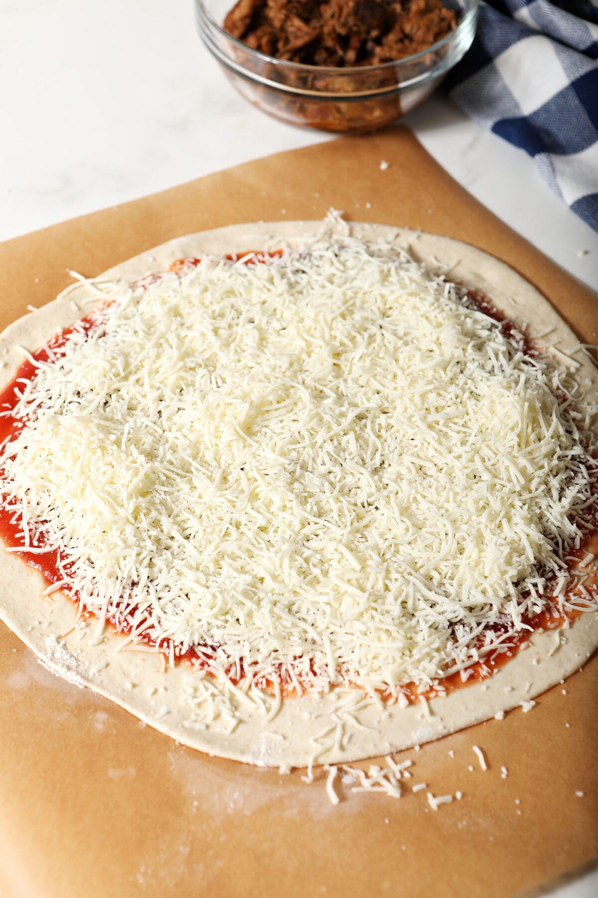 Shredded mozzarella on top of a pizza