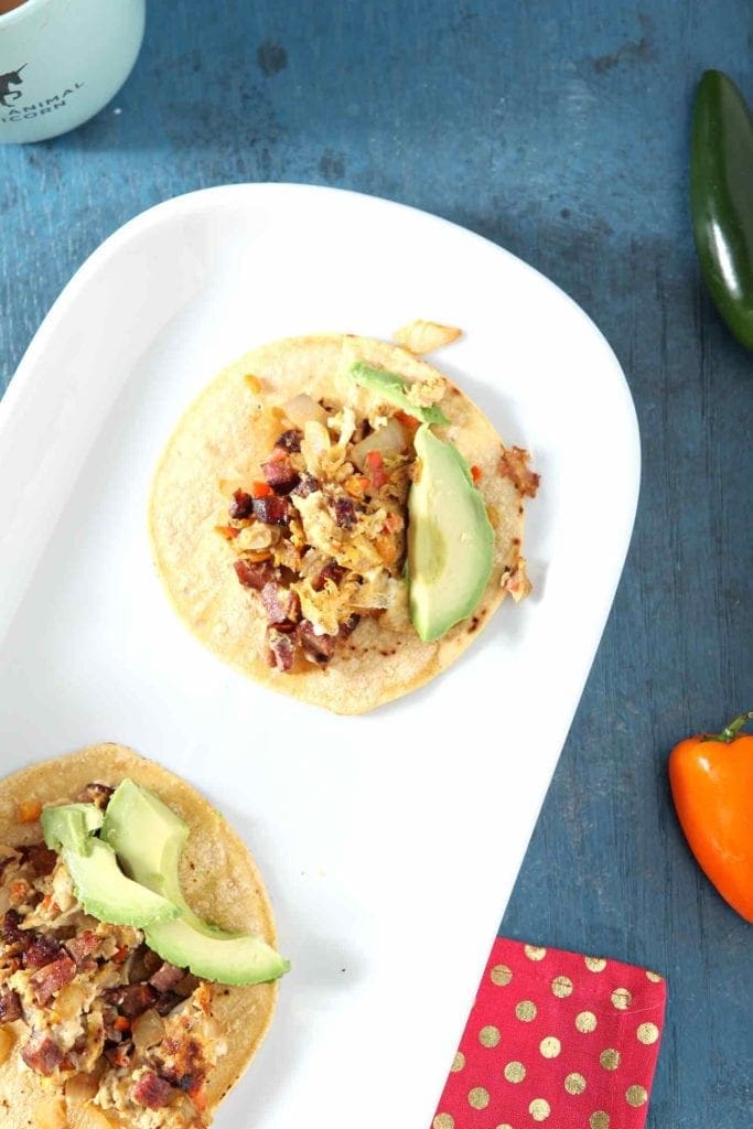 two andouille breakfast tacos on a white plate