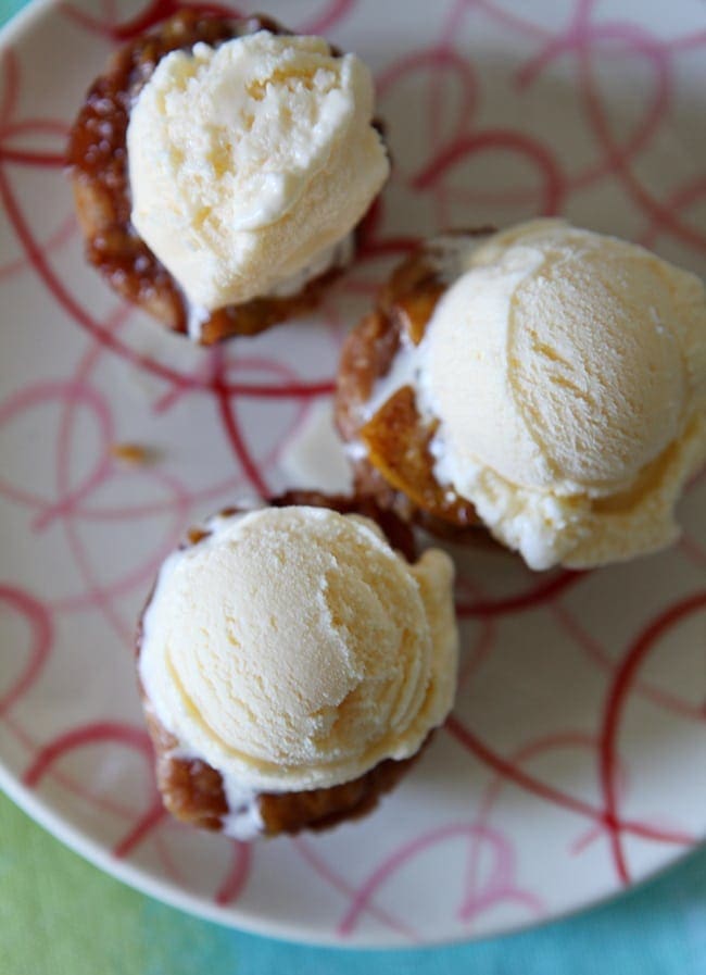 Overhead close up view of ice cream on top of mini peach pies 