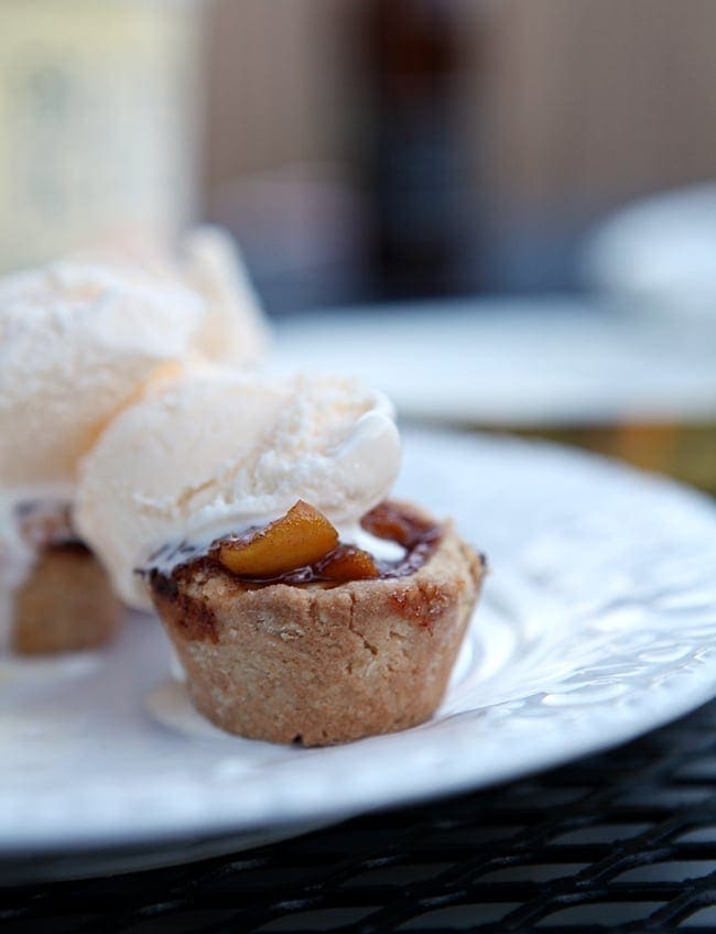 A close up of peach mini pies with a scoop on ice cream 