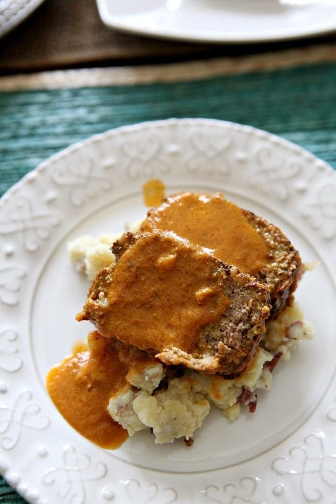 Overhead close up of gravy on top of Italian Meatloaf on white plate 