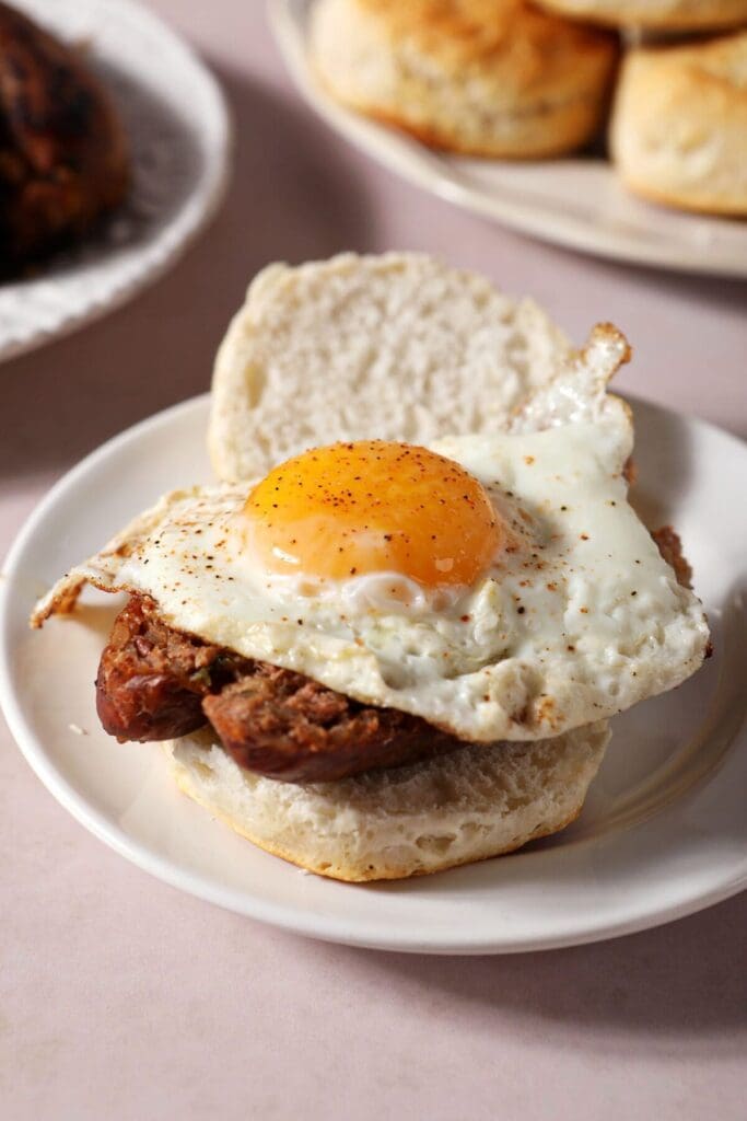 A fried egg on top of boudin and a biscuit