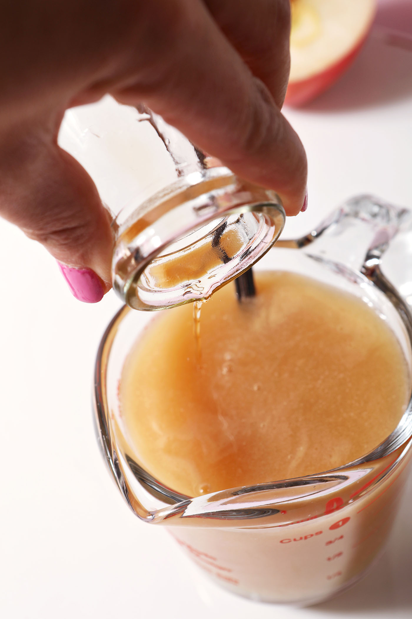 Bourbon pours into a liquid measuring cup with other ingredients