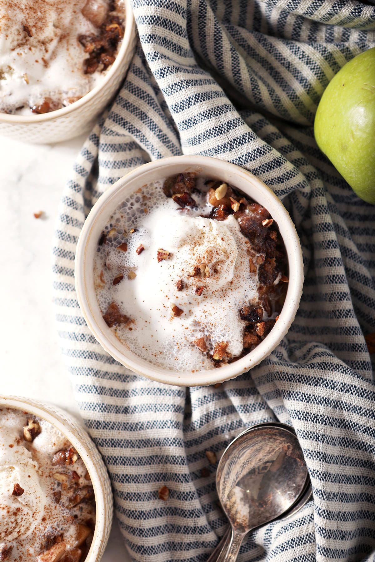 Close up of a bowl of apple crumble with ice cream on top