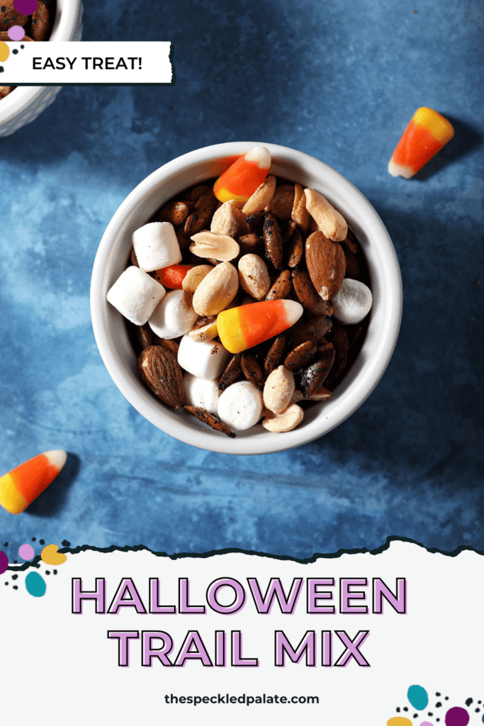 A small bowl of trail mix with nuts, candy corn and marshmallows with the text halloween trail mix