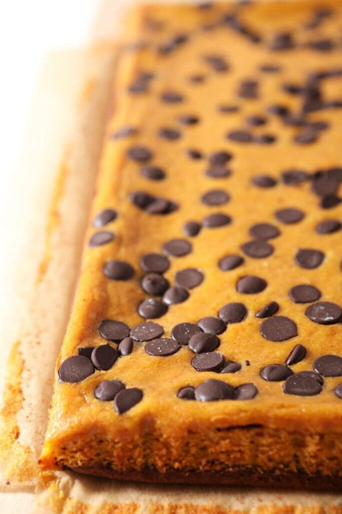 Pumpkin Cheesecake Brownie Bars on a wooden tray after baking and before slicing