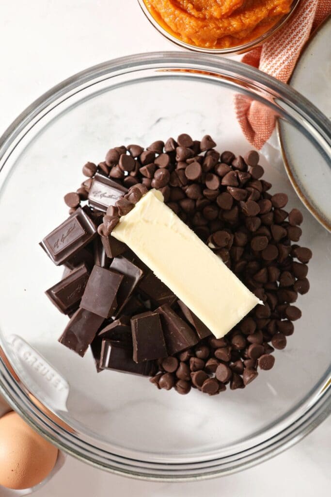 Chocolate chips and chocolate bars and butter in a bowl before melting