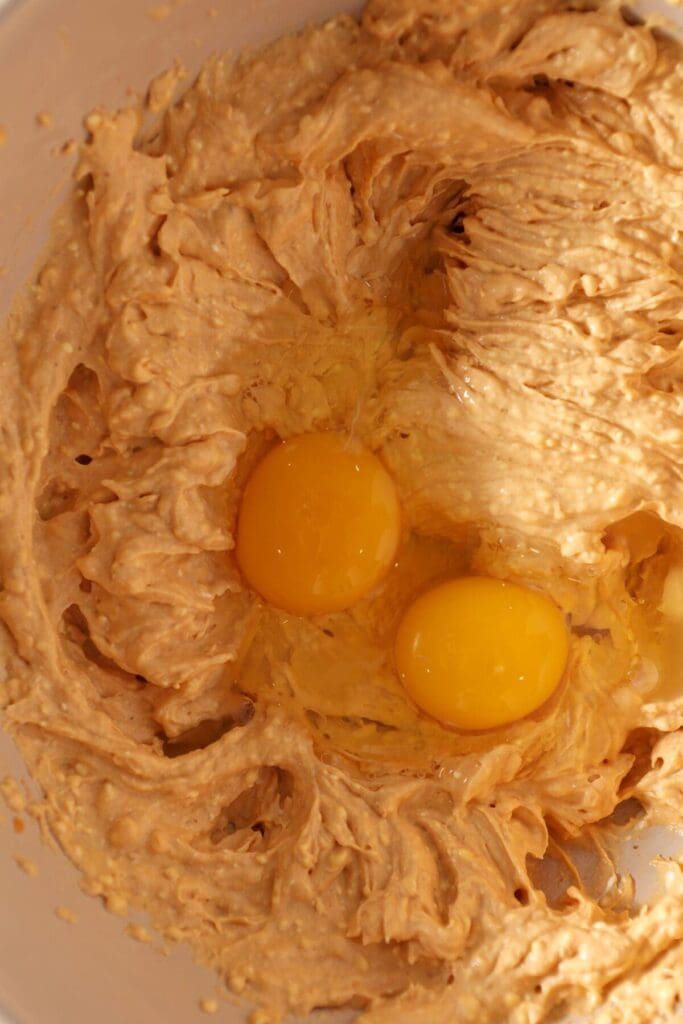 Whipped cream cheese and pumpkin with eggs and vanilla in a bowl