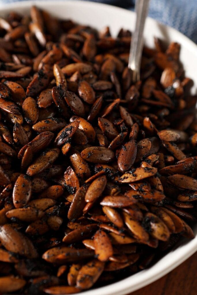 Close up of roasted pepitas in a white bowl