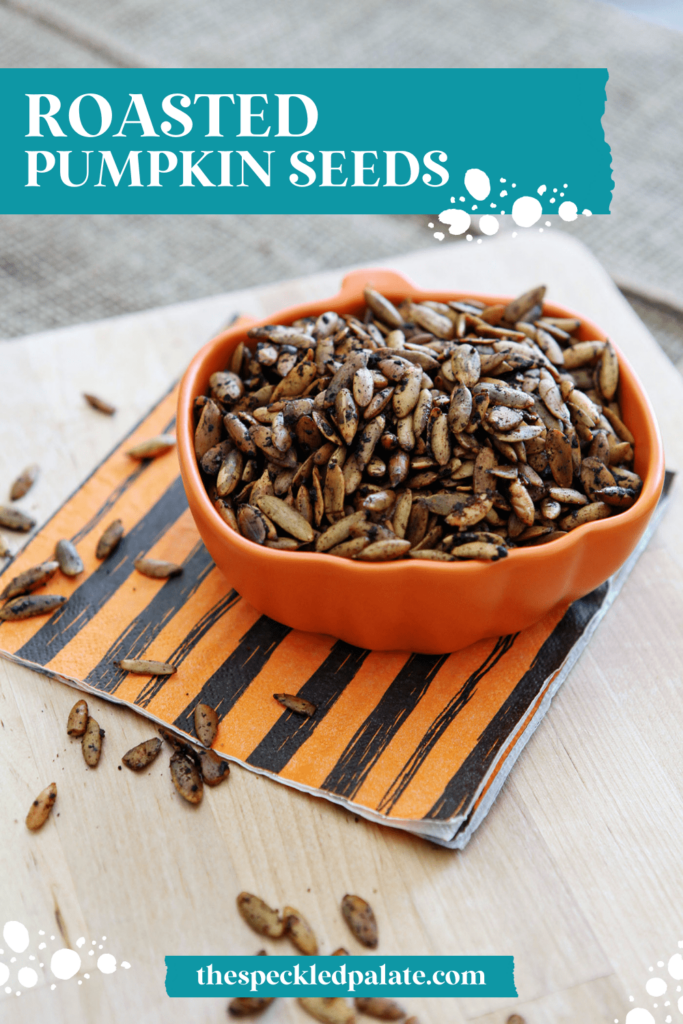 An orange pumpkin-shaped bowl of roasted pepitas with the text roasted pumpkin seeds