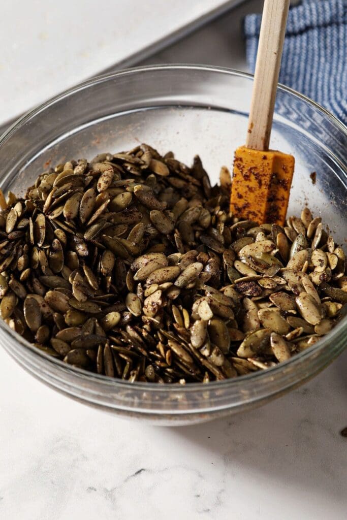 Pumpkin seeds tossed in spices in a bowl