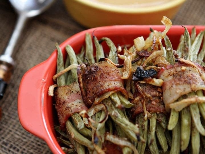 Fresh green beans are wrapped in strip of bacon and coated with a mustard vinaigrette before baking in the oven. These Green Bean Bacon Bundles make the perfect Thanksgiving side dish.