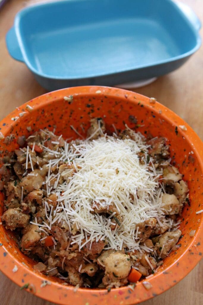 Parmesan cheese on top of a bread mixture before tossing to make stuffing