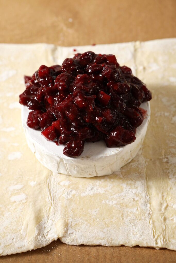 Cranberry chutney is piled on top of brie before both are wrapped in puff pastry