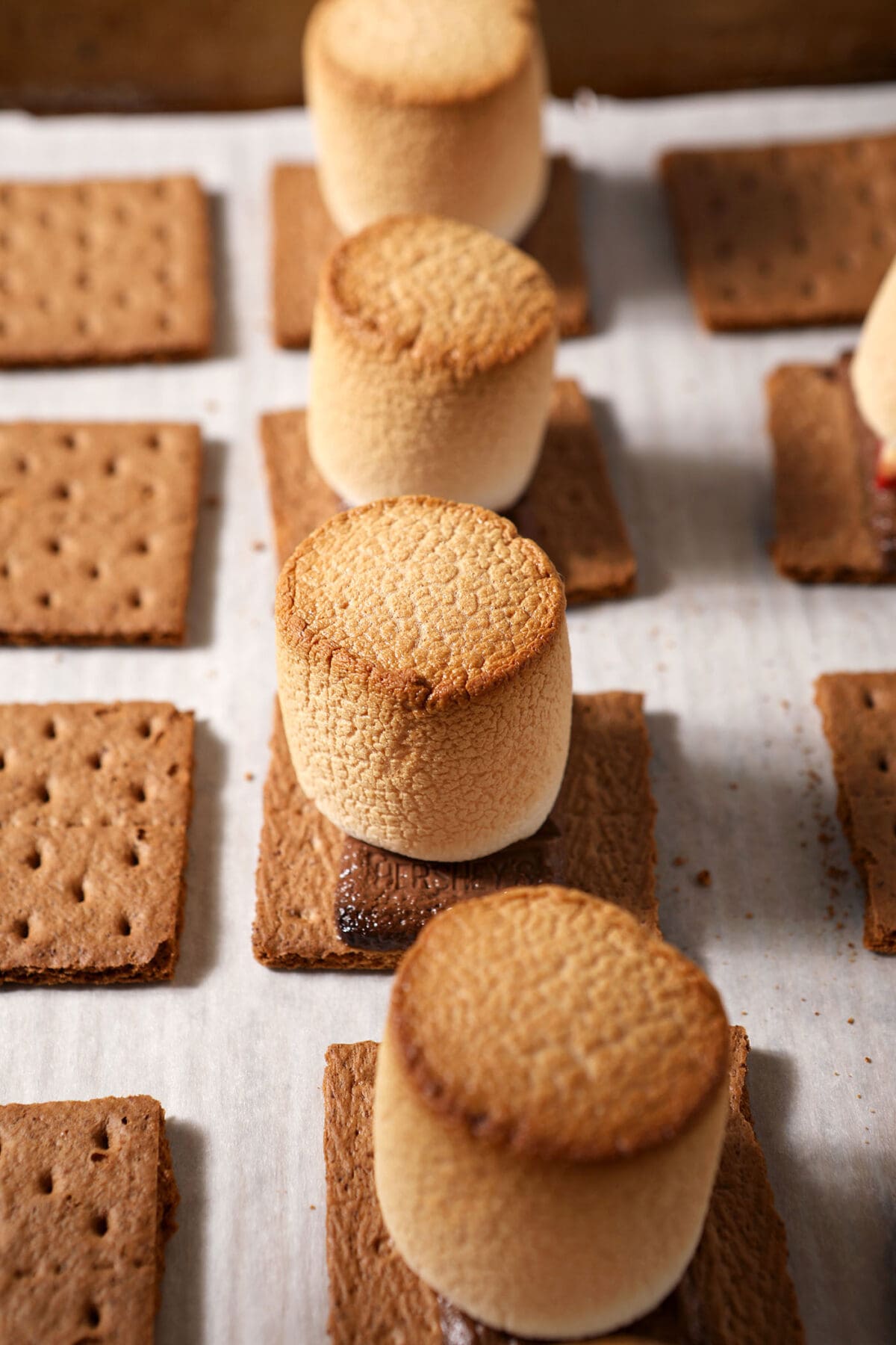 Baked s’mores with toasted marshmallows on a sheet pan before assembling
