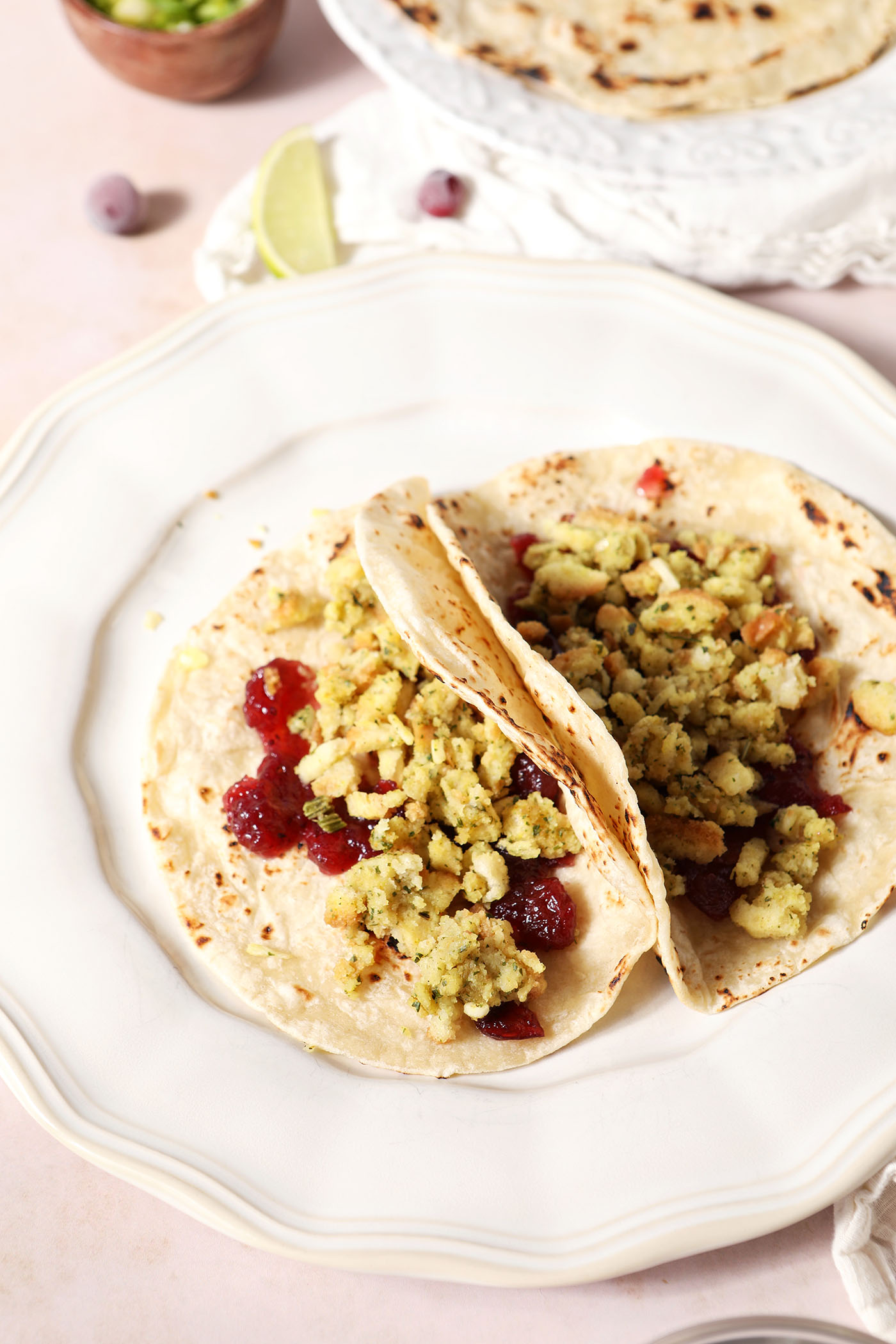 Stuffing on top of cranberry sauce in tortillas on a white plate
