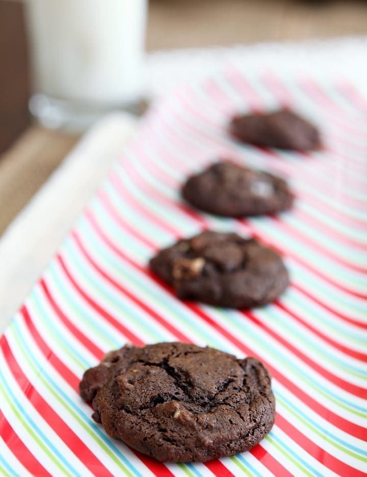 Several Chocolate Marshmallow Cookies with Pecans lined up on a red, green and white striped platter