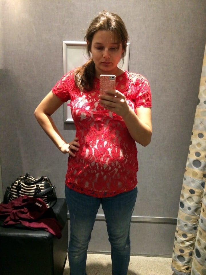 A woman standing in front of a mirror taking picture with phone 